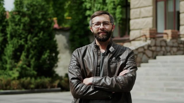 Successful attractive bearded man looking into the camera and smiling in slow motion