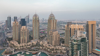 Fototapeta premium Aerial top view of Dubai Marina day to night timelapse. Modern towers and traffic on the road