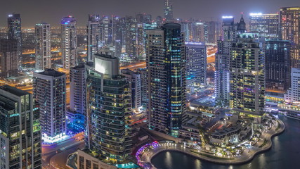 Obraz premium Aerial top view of Dubai Marina night timelapse. Modern towers and traffic on the road