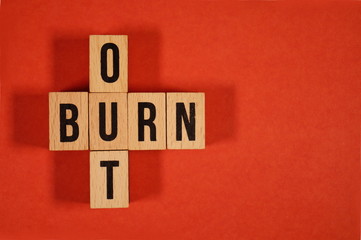 Obraz premium Burnout Word Written In Wooden Cube. Burn out, cube with letters. dice with text. concept of the destruction of shortcomings, fears, burnout at work, daily routine. medical or health care concept 