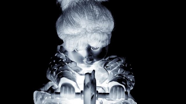 spooky doll on a rocking horse close up