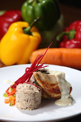 Roast chicken served with risotto and fresh vegetables with red wine.