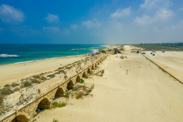 Fototapeta na wymiar Ruins of the Roman Aqueduct in the sand dunes of the ancient city of Caesarea Maritima built by Herod the Great bringing water from the hill nearby to the city