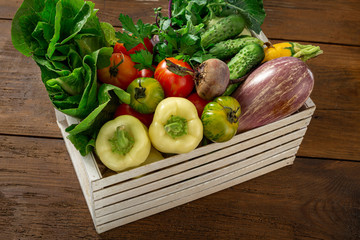 Harvesting concept. Wooden box with a bunch of different vegetables close up