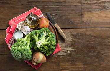 Raw ingredients for cooking cream broccoli soup on a wooden background