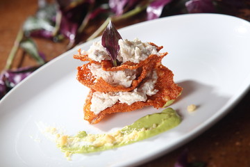 Chicharrón enchilado with goat cheese and avocado sauce.