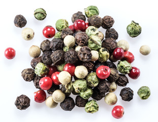 Black, white, green and red peppercorns isolated on white background.