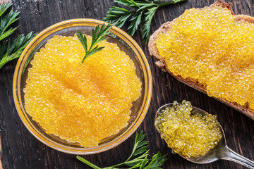 Pike caviar or roe in the bowl on wooden background.