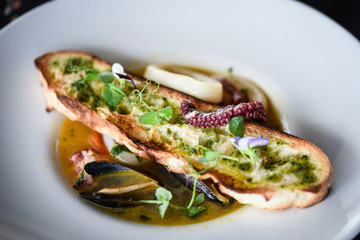 tasty seafood soup with fresh vegetables - shrimps, shells, octopus and crispy home made bread