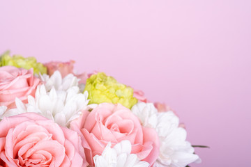 Bouquet of pink roses and white chrysanthemums, pink background, copy space