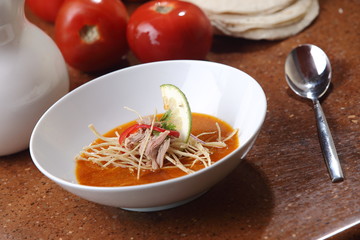 Tomato soup with tortilla strips and beef.
