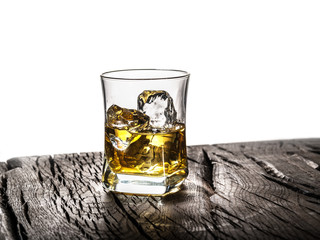 Whiskey glass or glass of whiskey with ice cubes on the table at white background.