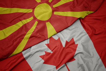 waving colorful flag of canada and national flag of macedonia.