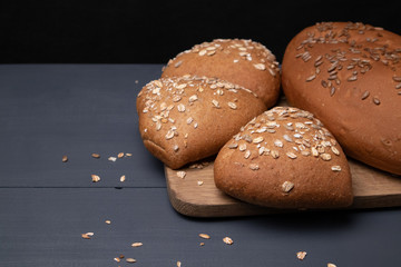 Side view of homemade fresh bread with buns on a blackboard