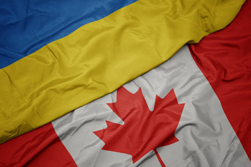 waving colorful flag of canada and national flag of ukraine.