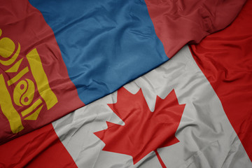 waving colorful flag of canada and national flag of mongolia.