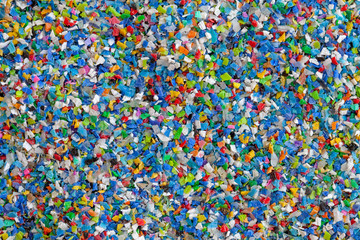 Crushed plastic granules for recycling.  Plastic crusher. Recycled plastic with mixed colors. The...