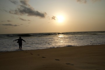 Fototapeta na wymiar silhouette of man on the beach at sunset