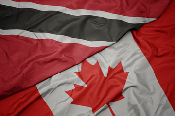 waving colorful flag of canada and national flag of trinidad and tobago.