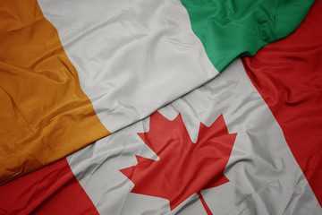 waving colorful flag of canada and national flag of cote divoire.