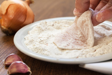Breading of raw chicken in flour with spices. Is ready to go. close up shot. onion garlic