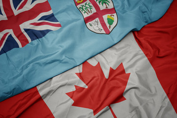 waving colorful flag of canada and national flag of Fiji .