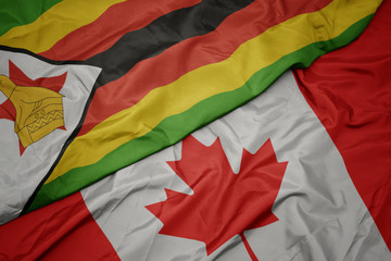 waving colorful flag of canada and national flag of zimbabwe.