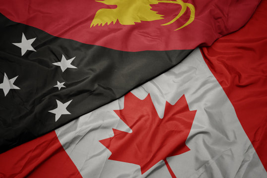 waving colorful flag of canada and national flag of Papua New Guinea.