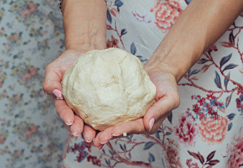 Pizza dough in female hands