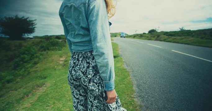 Young woman standing by roadside in the country