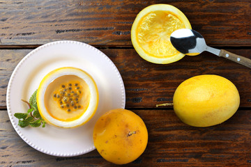 dessert passion fruit mousse in fruit rind on plate decorating rustic wooden table