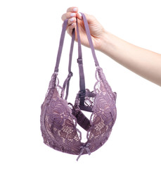 Female pink lace bra in hand on white background isolation