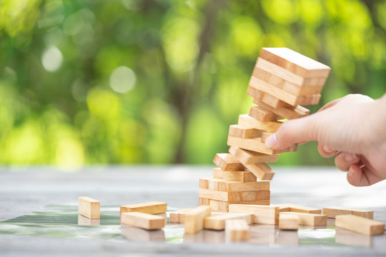 Closeup of asian woman's hand playing wood blocks stack game. Education and development concept.