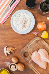Raw fillet. Cooking Chicken. Bread with flour, starch and spices. Lemon, fresh champignons, onions, garlic, wine, salt and olive oil. Wooden cutting board. Top layout
