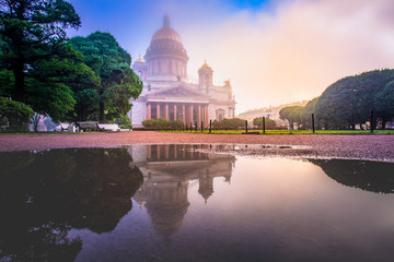 Russia. St. Petersburg on a cloudy day. St. Isaac's Cathedral in the fog. Reflection of the Cathedral and trees in a puddle. Business card of St. Petersburg. Panorama Of St. Petersburg