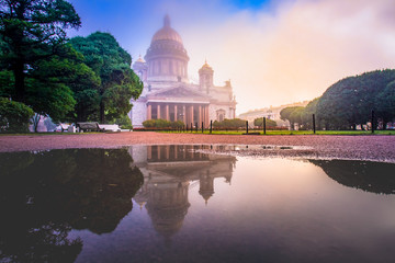Obraz premium Russia. St. Petersburg on a cloudy day. St. Isaac's Cathedral in the fog. Reflection of the Cathedral and trees in a puddle. Business card of St. Petersburg. Panorama Of St. Petersburg