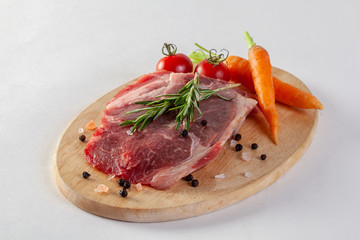 Beef steak with vegetables and spices on a cutting board