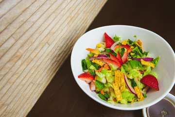Fresh Summer Salad with Strawberries in a Wide Bowl slanted