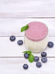 Blueberry yogurt glass on white wooden table