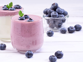 White yogurt and blueberry yogurt on wooden table