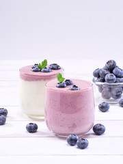 Blueberry yogurt and white yogurt on wooden table