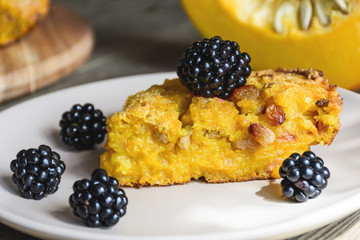 Homemade fresh round bright orange sliced pumpkin tart pie recipe with raisins on rustic wood background. Pumpkin Pie decorated for Halloween. Celebrating Thanksgiving Holiday Tradition Concept