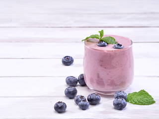 Blueberry yogurt glass on white wooden table