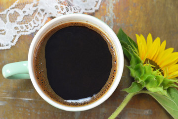 Top view of cup of black coffee on rusty background