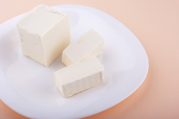 fresh chilled diced butter on a pink background