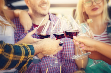 Group of young friends celebrating at dinner - Detail of hands while toasting with glasses of wine -  Happy people at a terrace party -Concept of friendship