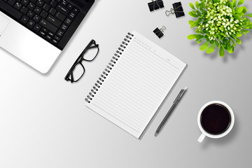 Office desk or education desk with laptop, Pen, Notebook, paper clip, glasses, Flower vase and coffee, top view 