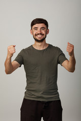 Fototapeta premium happy young man standing over white background. Looking at camera. rejoices at winning. victory, good bet
