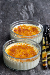 Closeup of creme brulee in glass jars on rustic wooden table