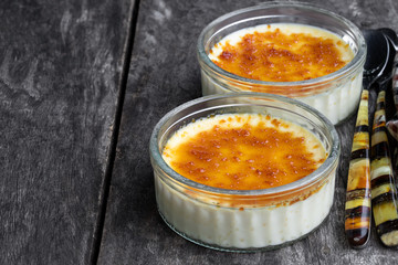Closeup of creme brulee in glass jars on rustic wooden table